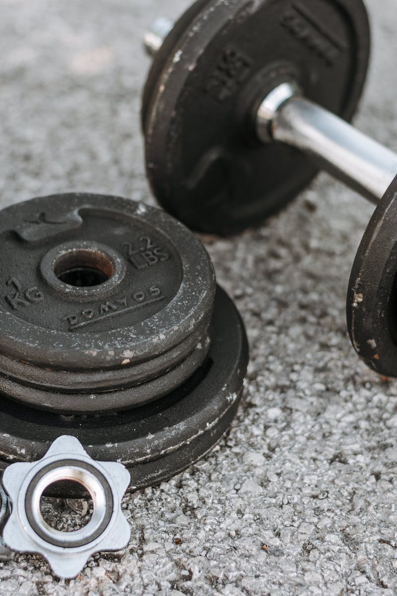 Weathered heavy adjustable dumbbell with details for regulating weight for muscle training on paved ground